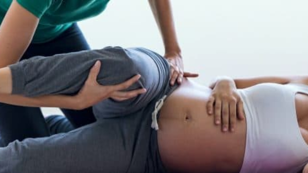 physiotherapist-helping-to-beautiful-pregnant-UYVEVLP-copy-e1587599259399