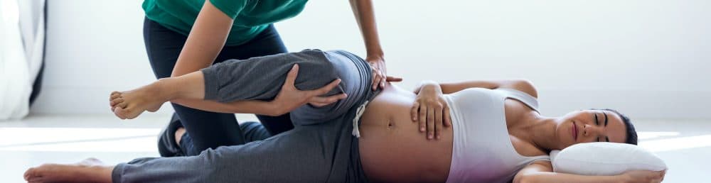physiotherapist-helping-to-beautiful-pregnant-UYVEVLP-copy-e1587599259399